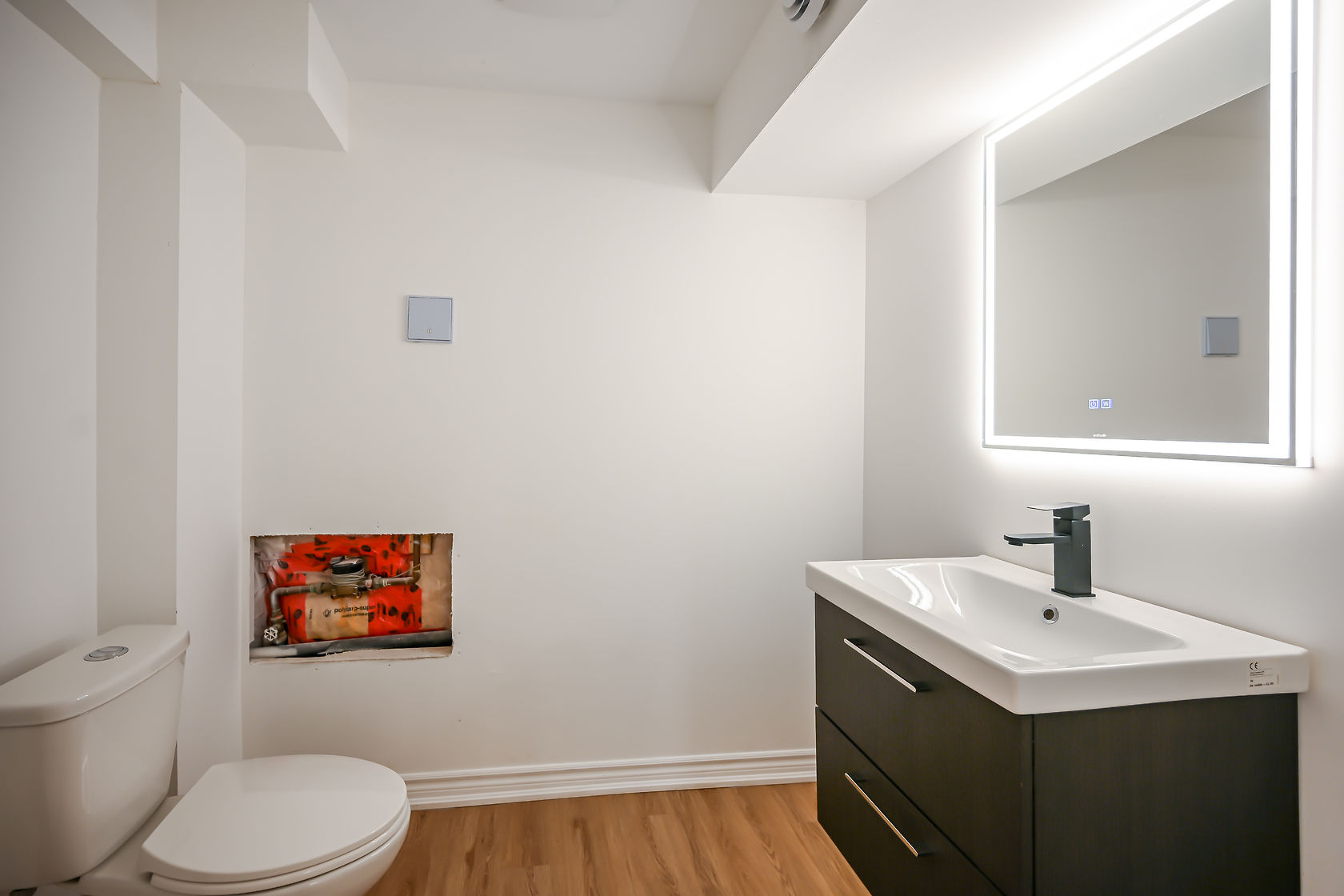 Clean modern bathroom with LED mirror and floating vanity — strong portfolio piece showing contemporary design trends — Stonehenge, Hamilton | MTC Renovations