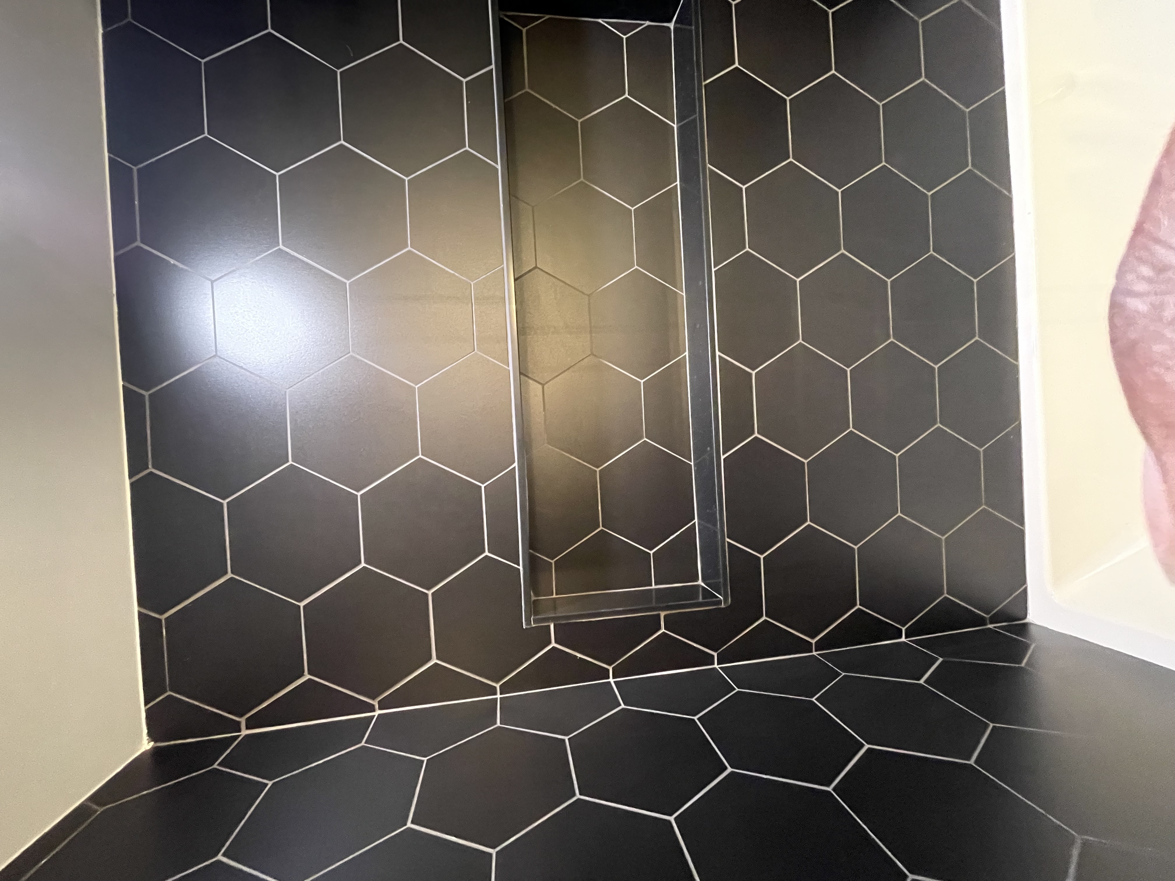 Stunning hexagon tile work with perfect grout lines and built-in niche — premium craftsmanship showcase — Queensway, Hamilton | MTC Renovations