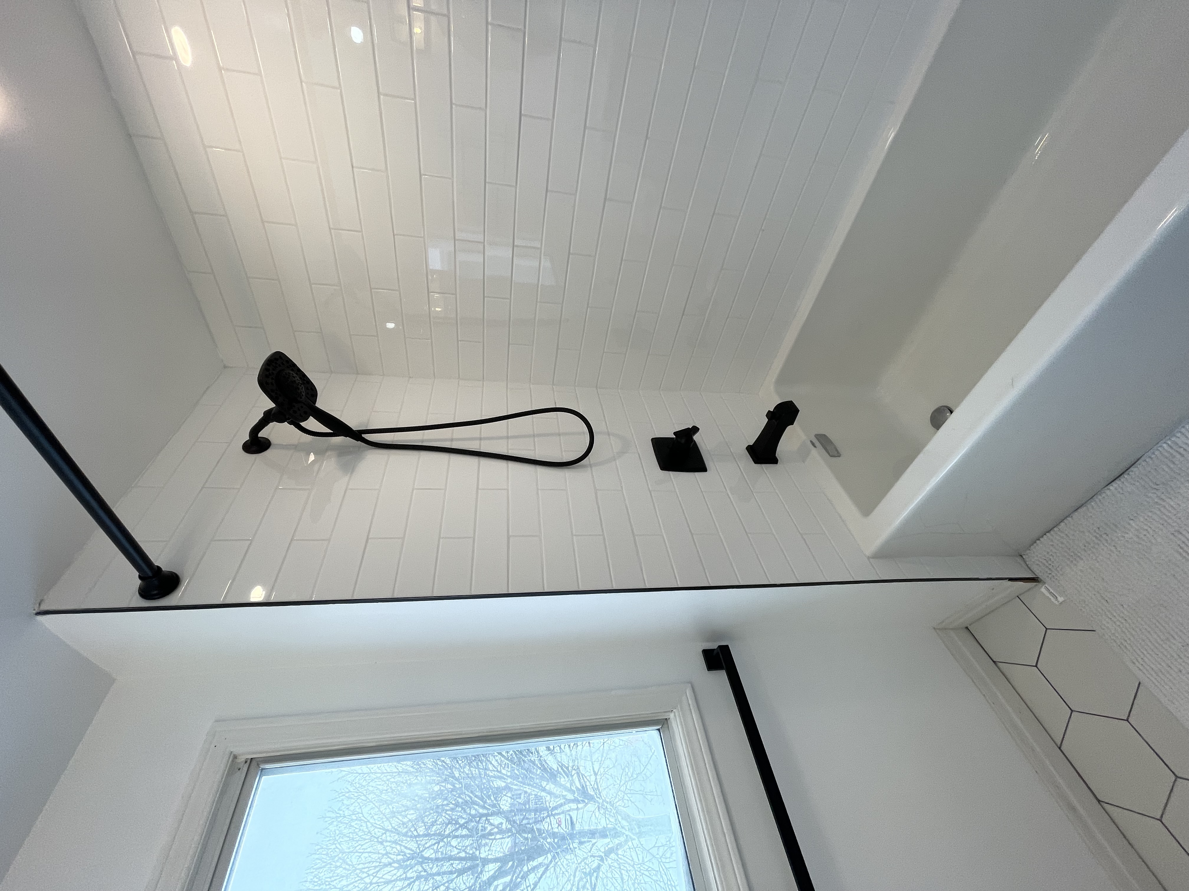 Clean finished bathroom with bright natural light, classic subway tile, and black fixtures — strong portfolio shot — Buchanan, Hamilton | MTC Renovations