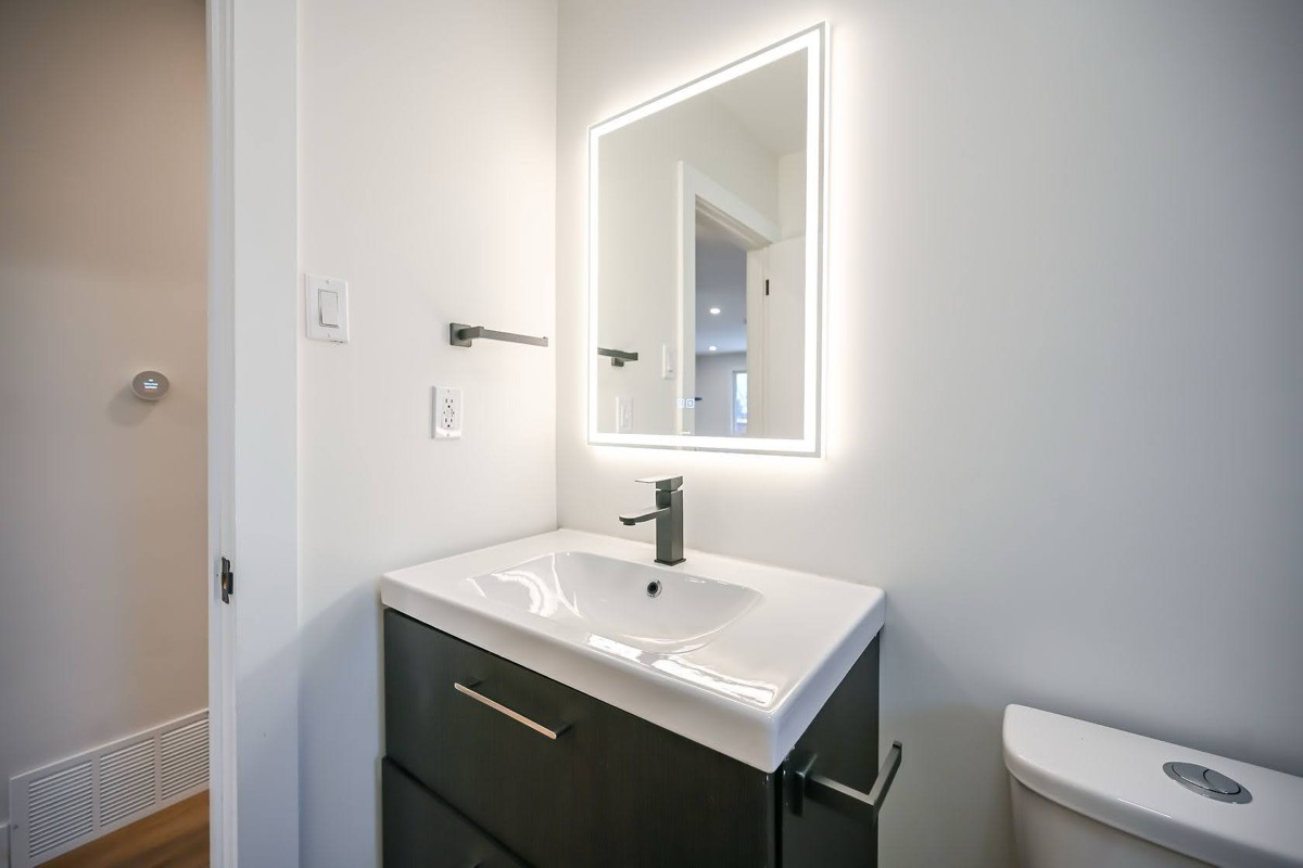 Clean modern bathroom with LED mirror and dark vanity contrast — excellent portfolio shot with virtual tour quality — Winchester, Hamilton | MTC Renovations