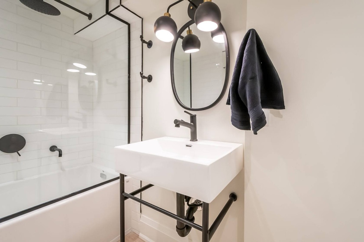 Modern bathroom with striking black fixtures and clean white tile — premium portfolio shot with strong design appeal — Rosedene, Hamilton | MTC Renovations