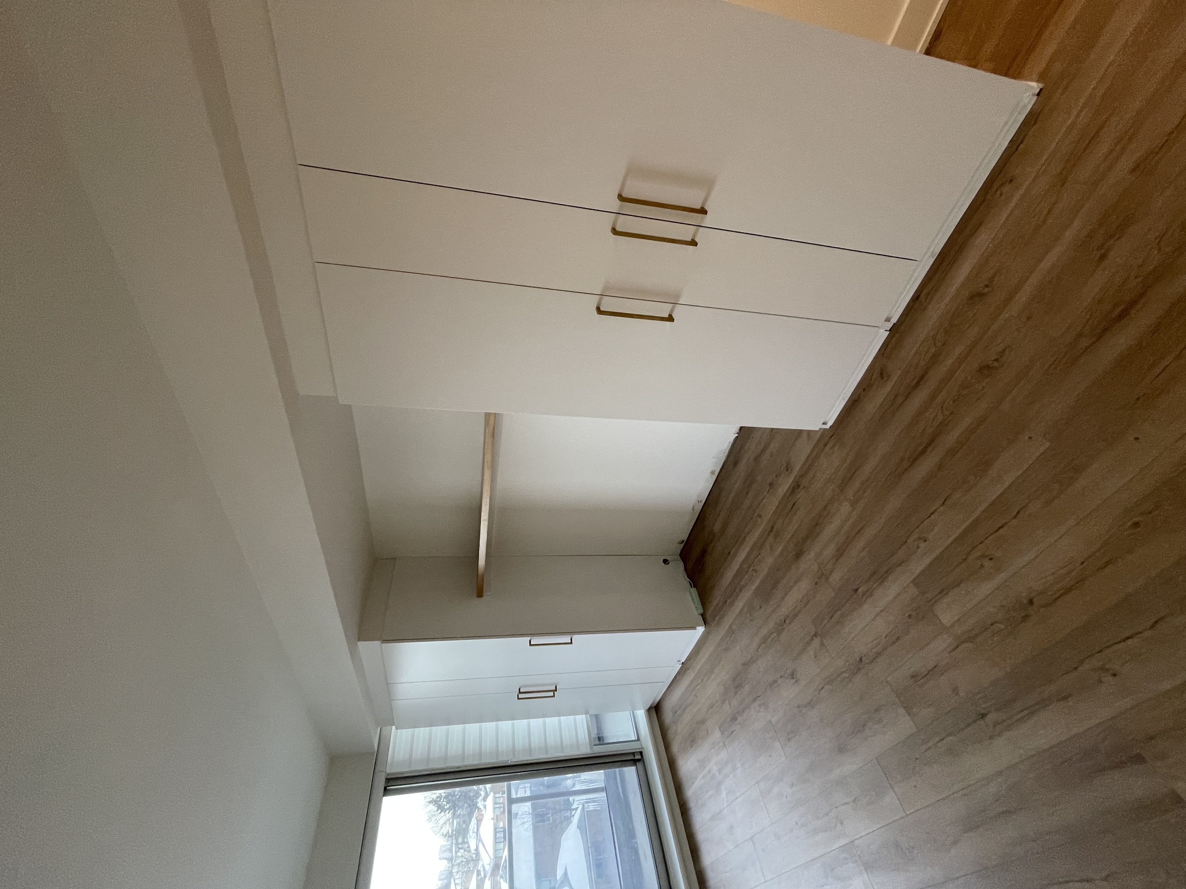 Clean modern bedroom with built-in storage, excellent natural light, and warm wood flooring — Queensway, Hamilton | MTC Renovations