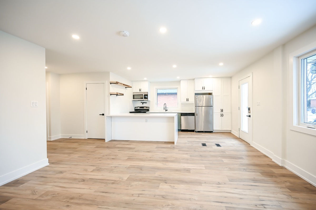 Bright finished kitchen with beautiful hardwood floors and clean white cabinetry — Winchester, Hamilton | MTC Renovations