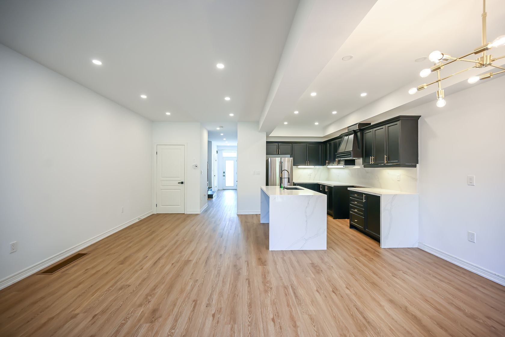 Bright open-concept kitchen with excellent lighting and clean staging — premium portfolio shot showing full space flow — Stonehenge, Hamilton | MTC Renovations