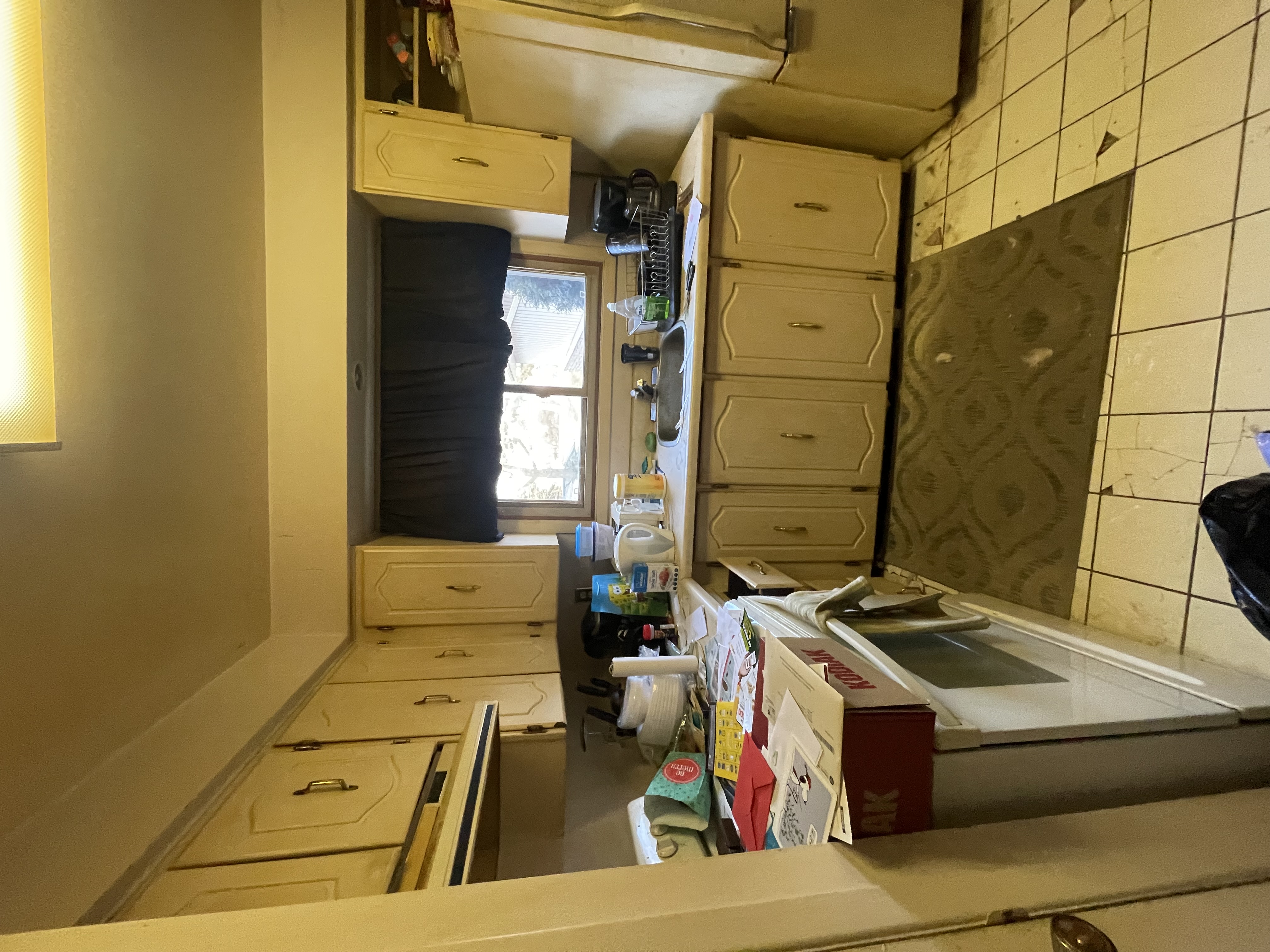 Dated yellow kitchen with lived-in clutter clearly documents pre-renovation state — excellent before/after storytelling potential — Gateshead, Hamilton | MTC Renovations