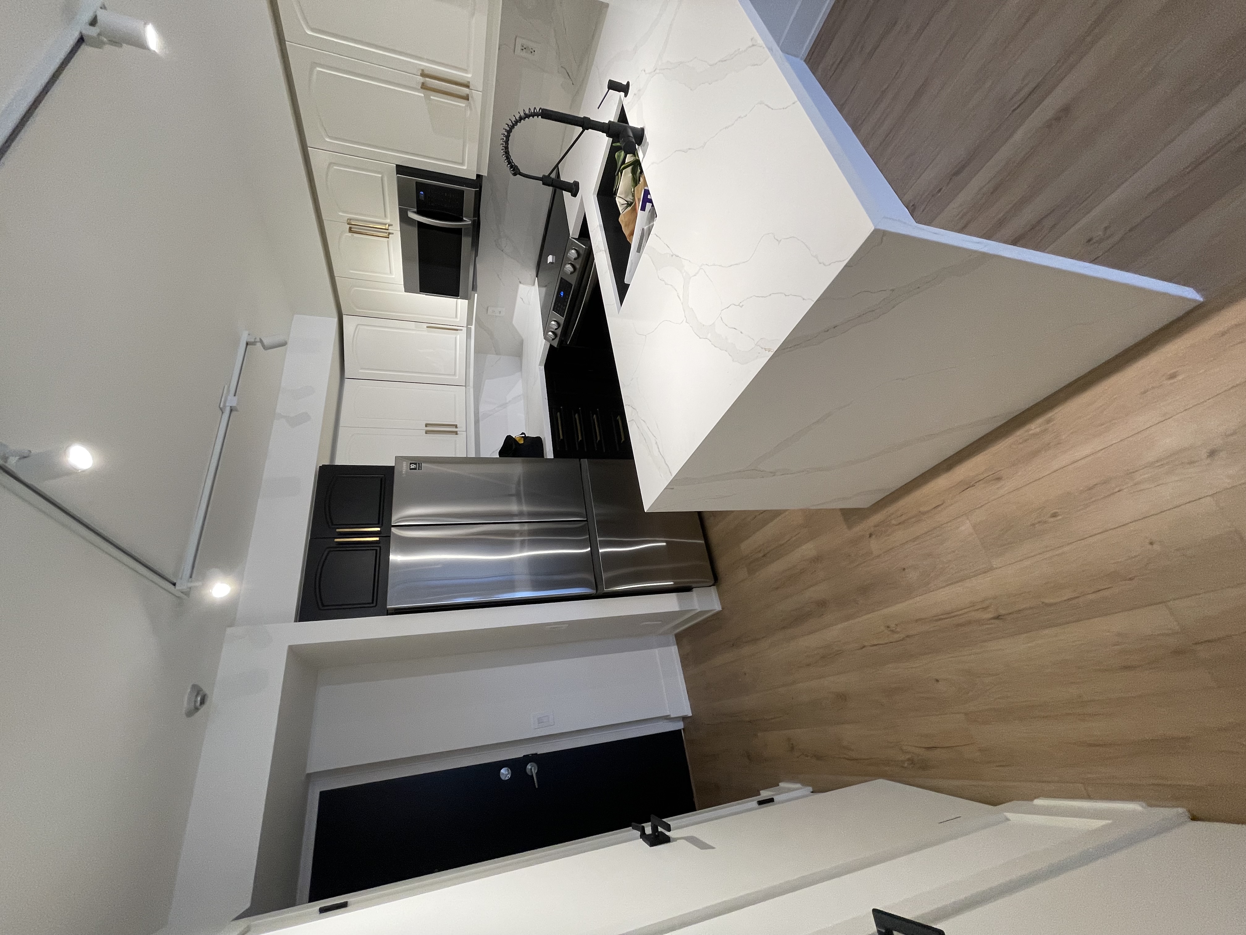 Clean modern kitchen with strong material contrast and professional lighting — solid portfolio piece — Queensway, Hamilton | MTC Renovations
