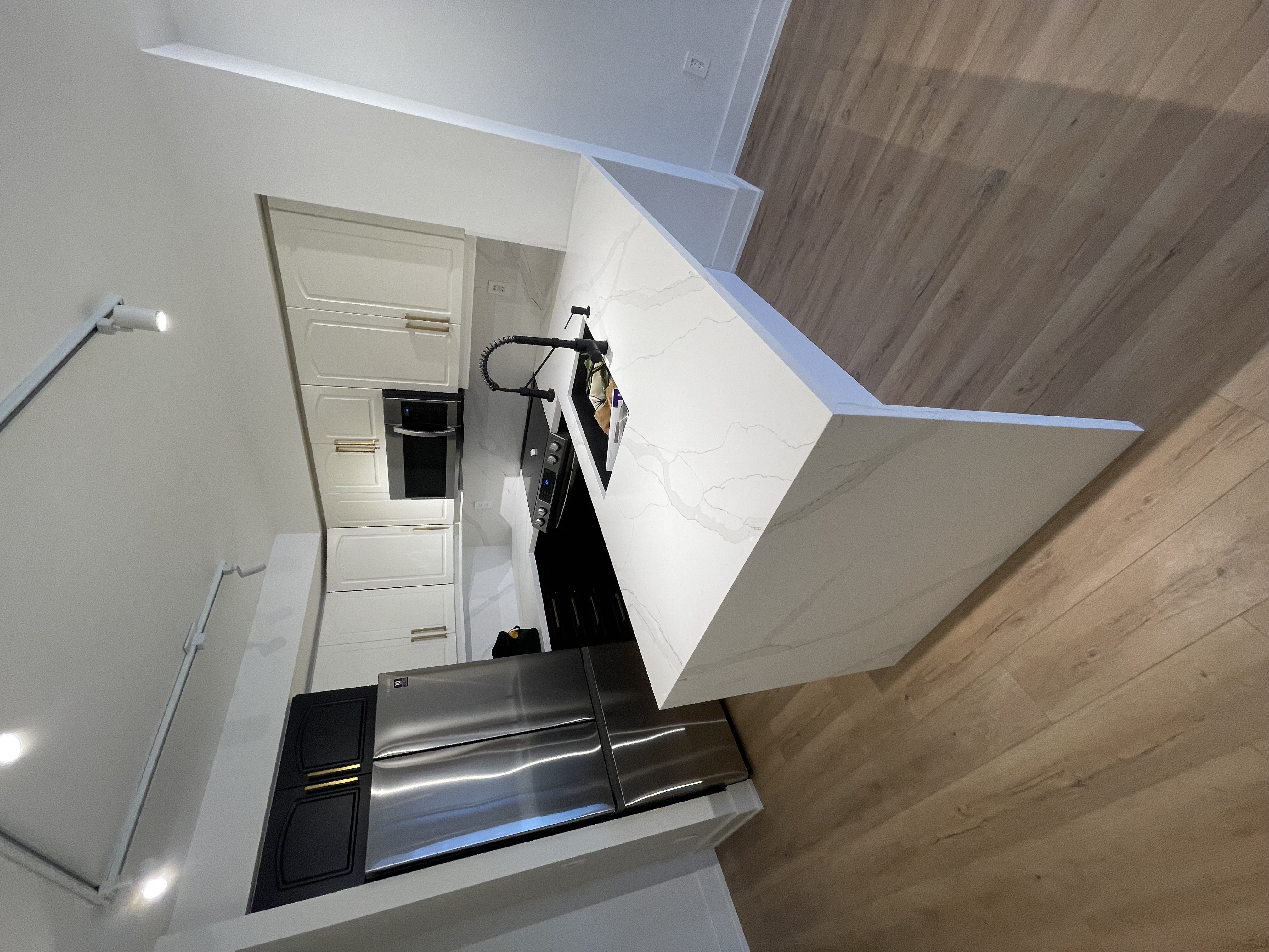 Clean modern kitchen with strong material contrast and professional staging - excellent portfolio shot despite artificial lighting — Queensway, Hamilton | MTC Renovations
