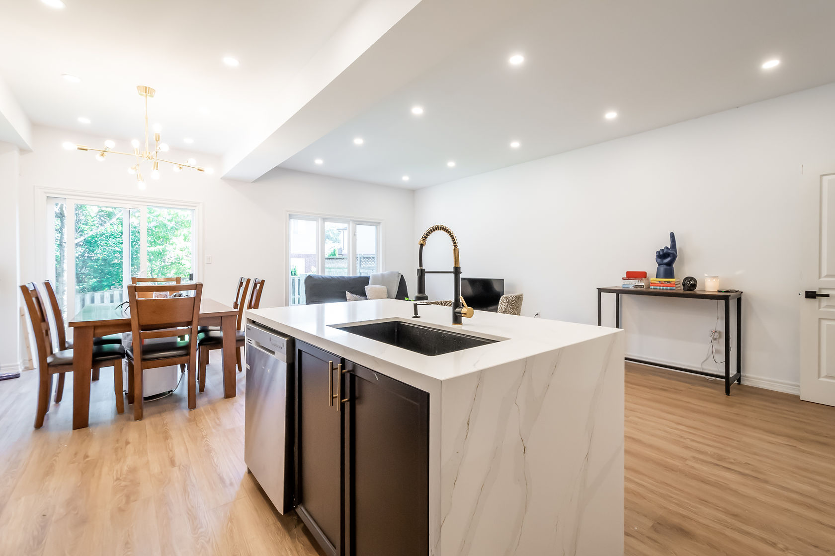 Bright open-concept kitchen with dramatic waterfall quartz island and excellent natural light — premium portfolio shot — Stonehenge, Hamilton | MTC Renovations