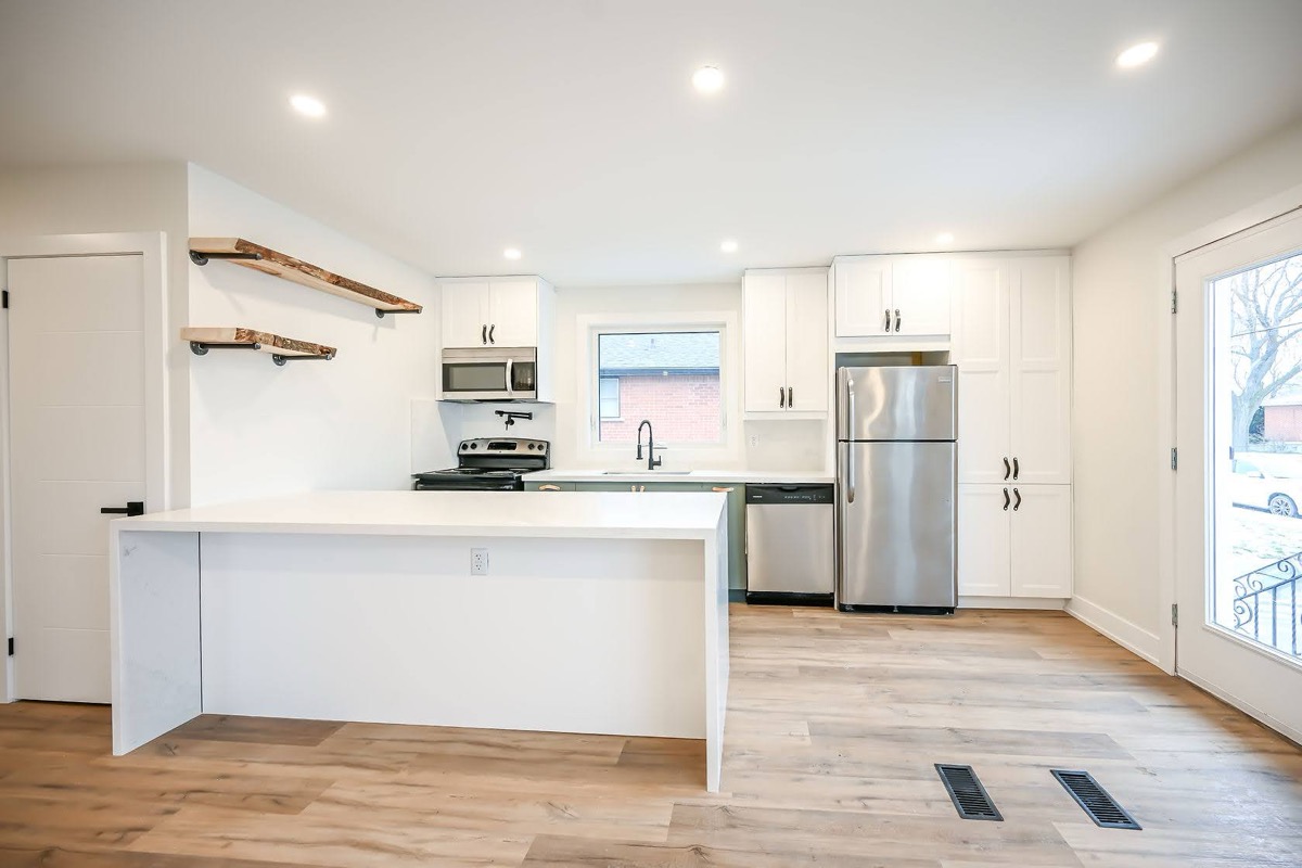 Bright finished kitchen with live-edge wood shelves and clean white cabinetry — premium portfolio shot with strong material contrast — Winchester, Hamilton | MTC Renovations
