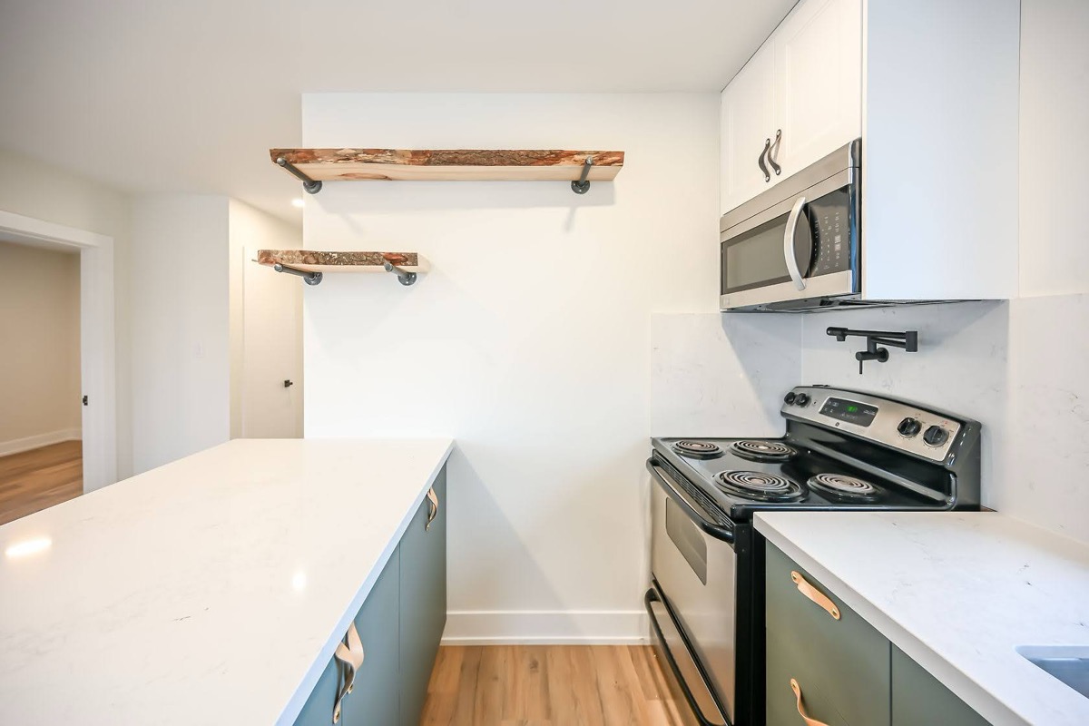 Clean finished kitchen with live-edge wood shelves and two-tone cabinets — strong portfolio shot with current design trends — Winchester, Hamilton | MTC Renovations