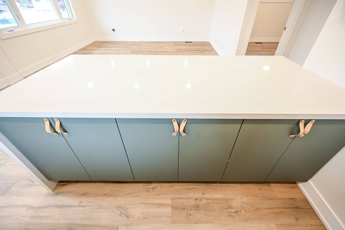Clean finished kitchen island with modern sage cabinets and quartz countertop — strong portfolio piece with good natural lighting — Winchester, Hamilton | MTC Renovations