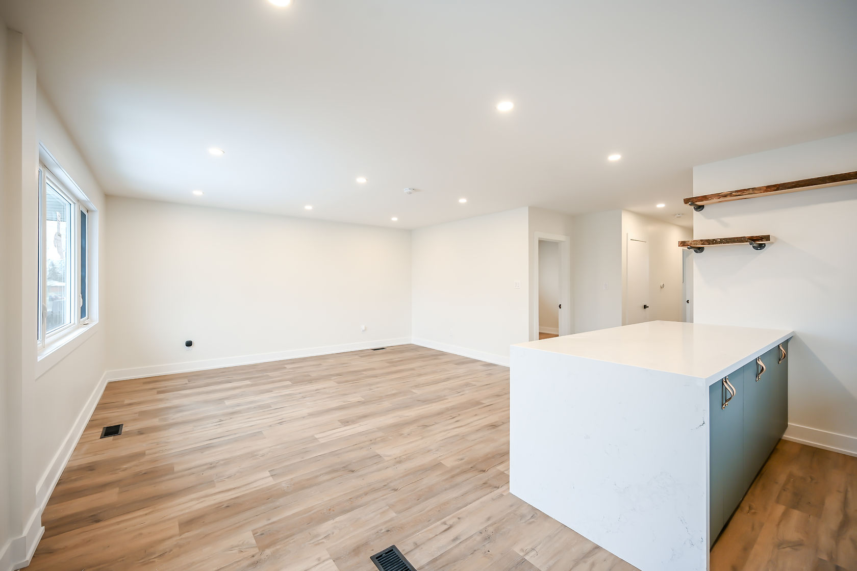 Clean finished kitchen with warm wood floors and modern island — strong wide-angle portfolio shot — Winchester, Hamilton | MTC Renovations
