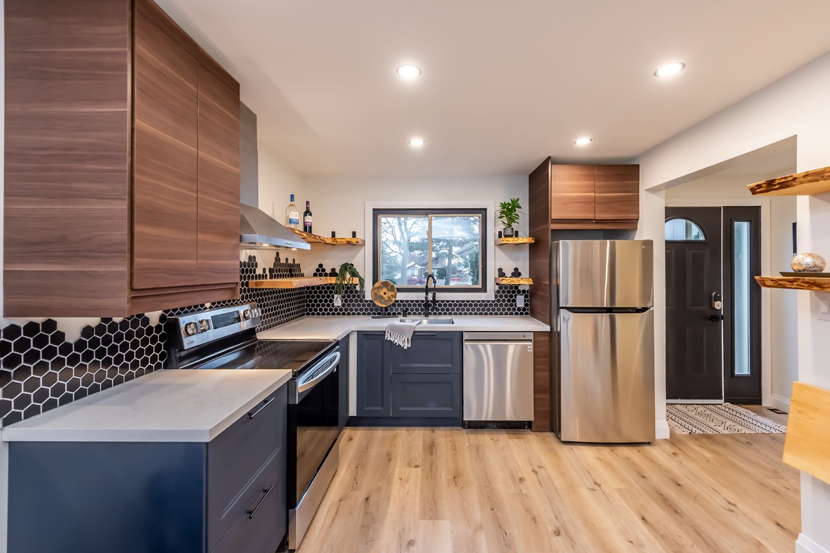 Premium finished kitchen with dramatic two-tone cabinetry, hex tile backsplash, and excellent wide-angle composition — Gateshead, Hamilton | MTC Renovations
