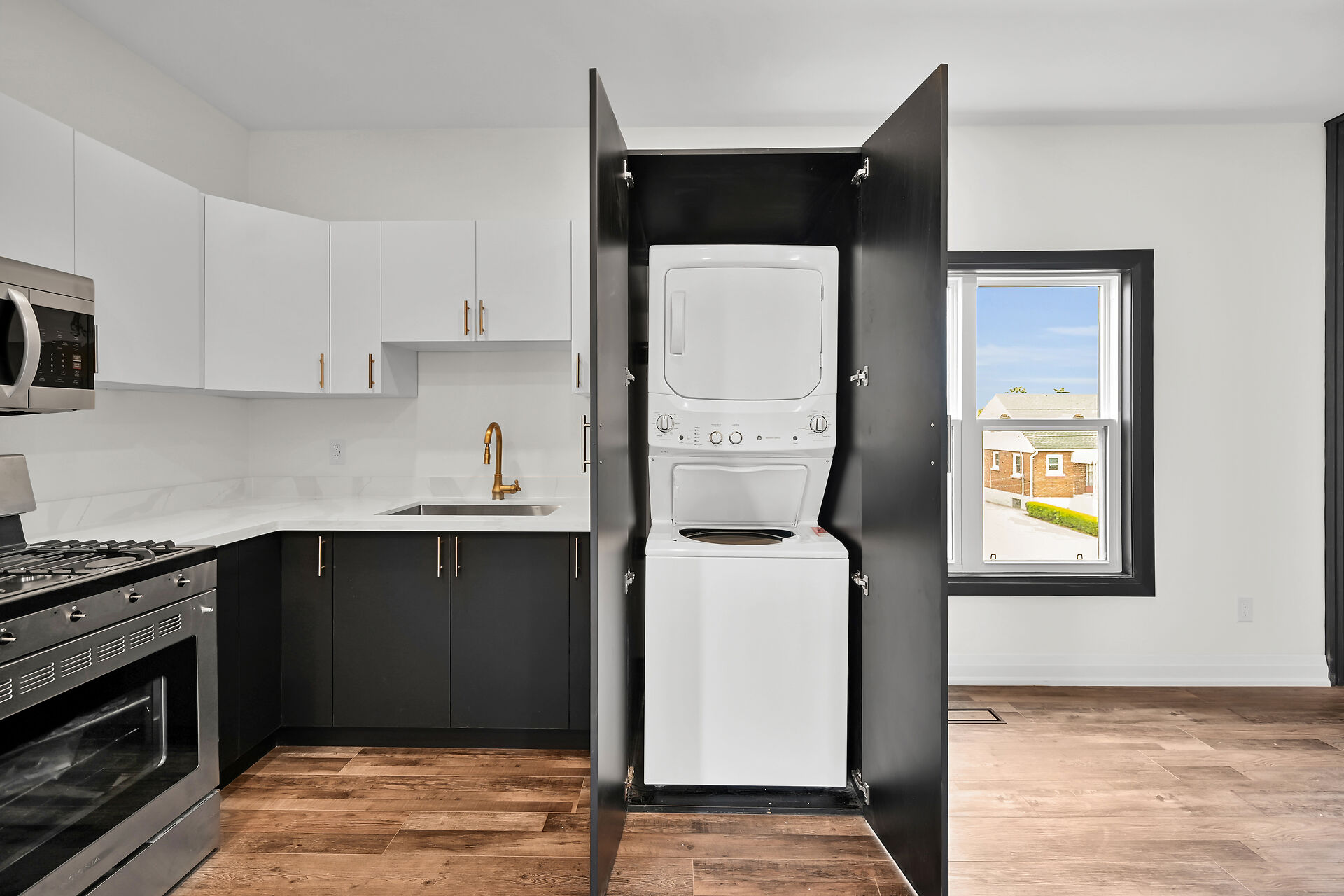 Bright finished kitchen with smart laundry integration and strong material contrast — premium portfolio shot — Queensdale, Hamilton | MTC Renovations
