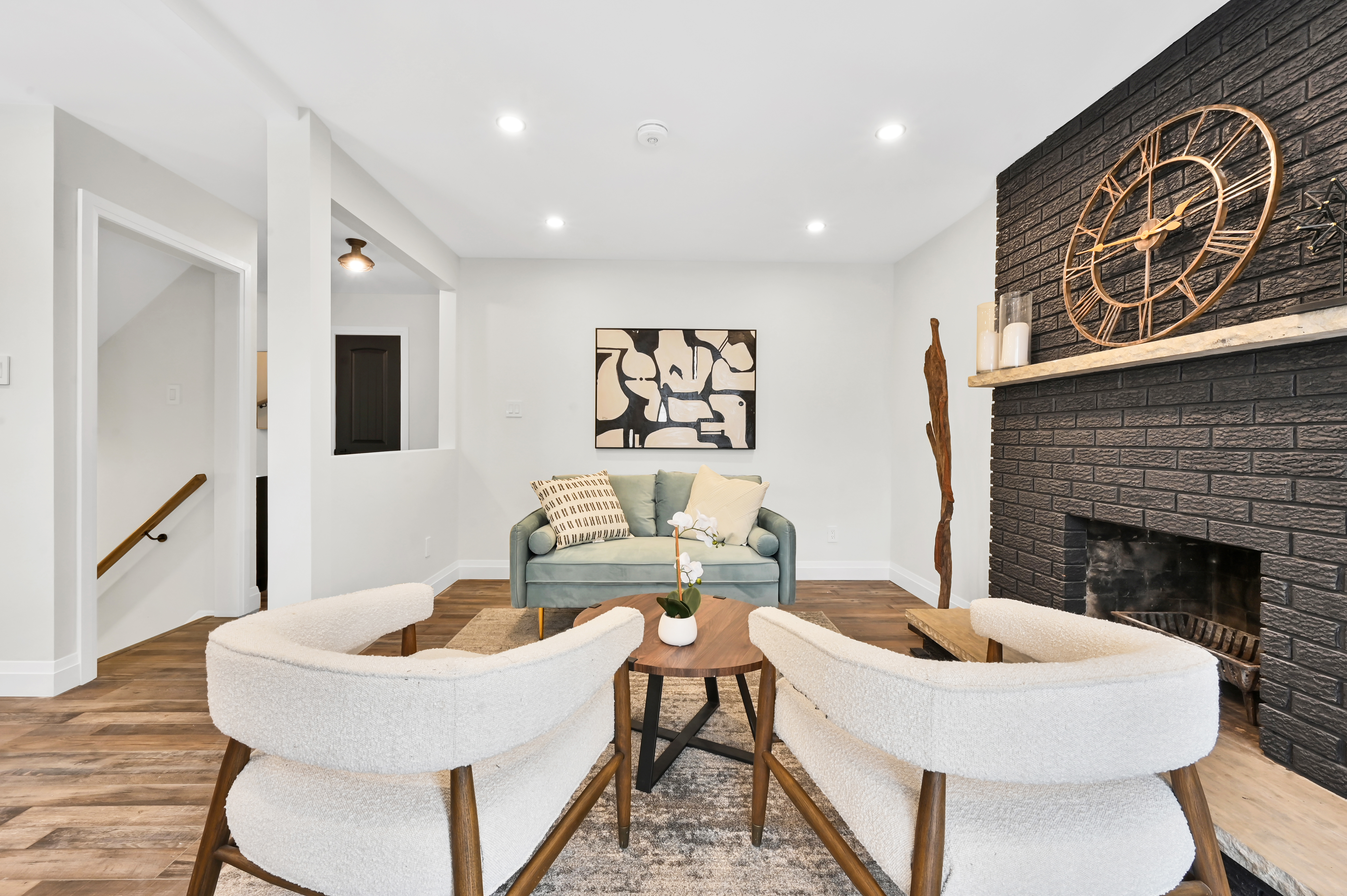 Professionally staged living room with dramatic brick fireplace and freshly painted walls — Kron, Hamilton | MTC Renovations