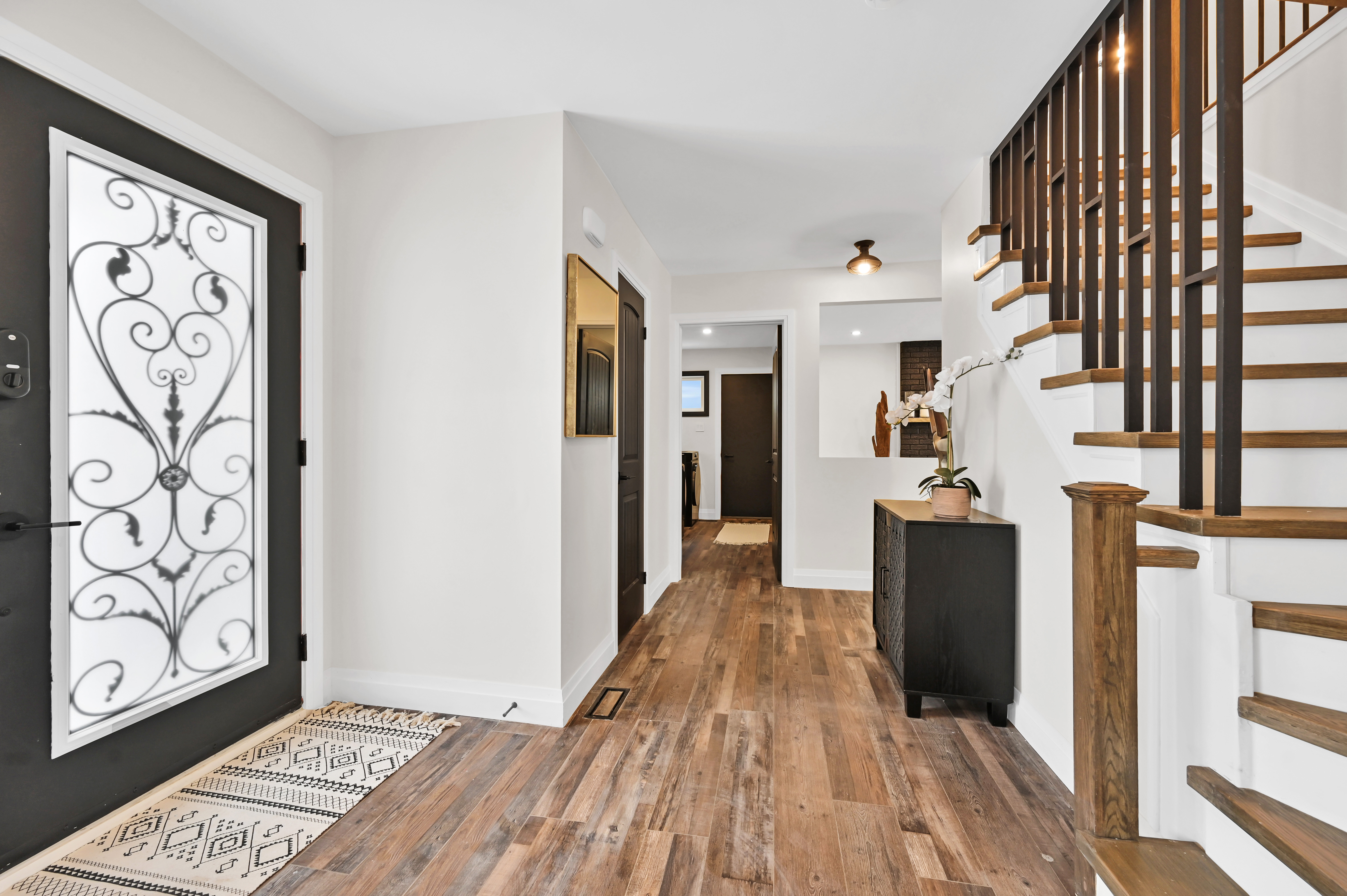 Bright painted entryway with beautiful wood stair details and clean modern wall finishes — Kron, Hamilton | MTC Renovations