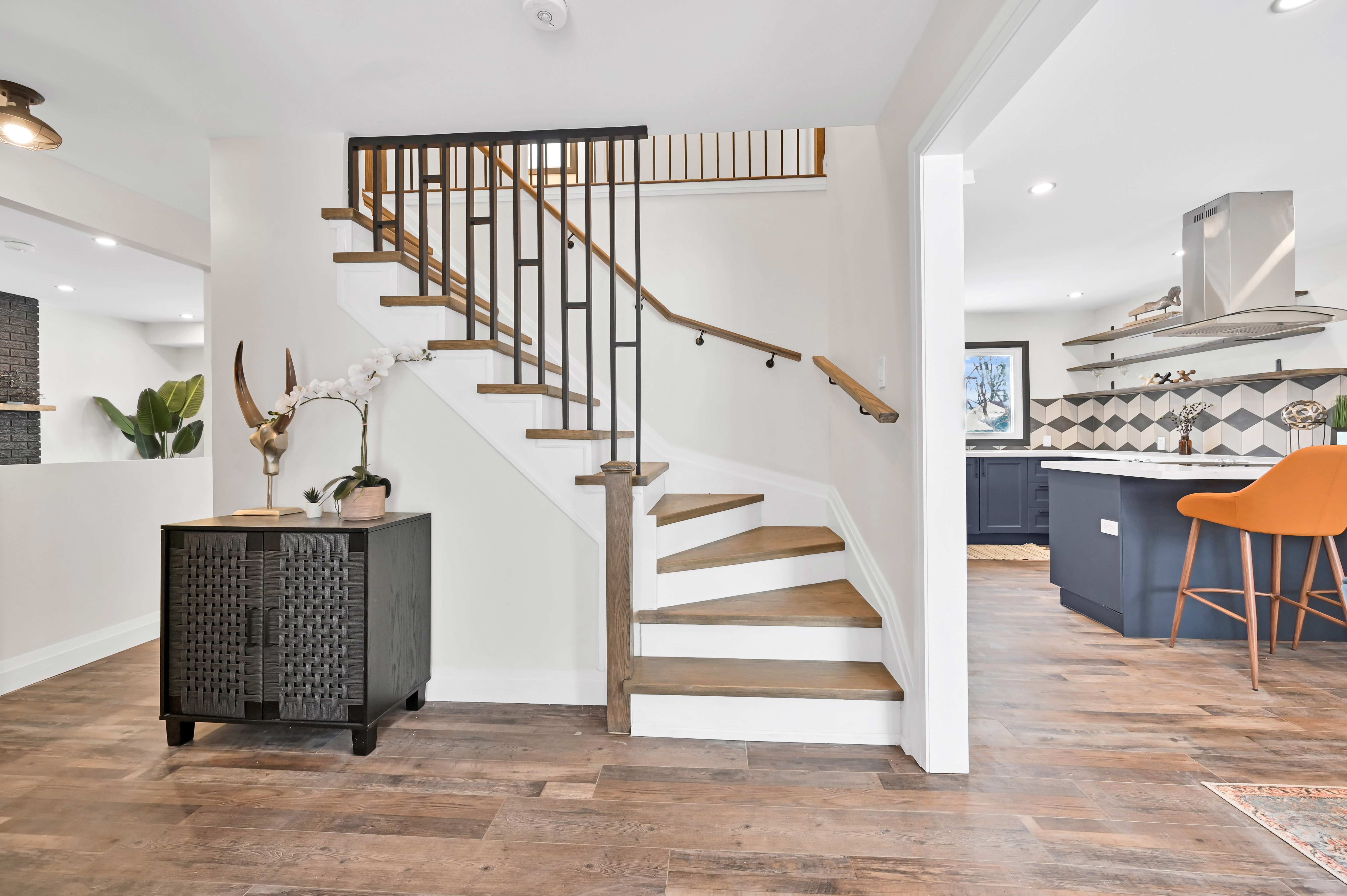 Finished stairway with modern railings, clean painted walls, and open kitchen view — Kron, Hamilton | MTC Renovations
