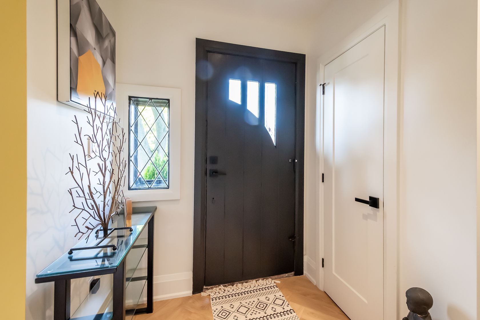 Bright painted entryway with dramatic dark door and clean white wall finishes — Rosedene, Hamilton | MTC Renovations